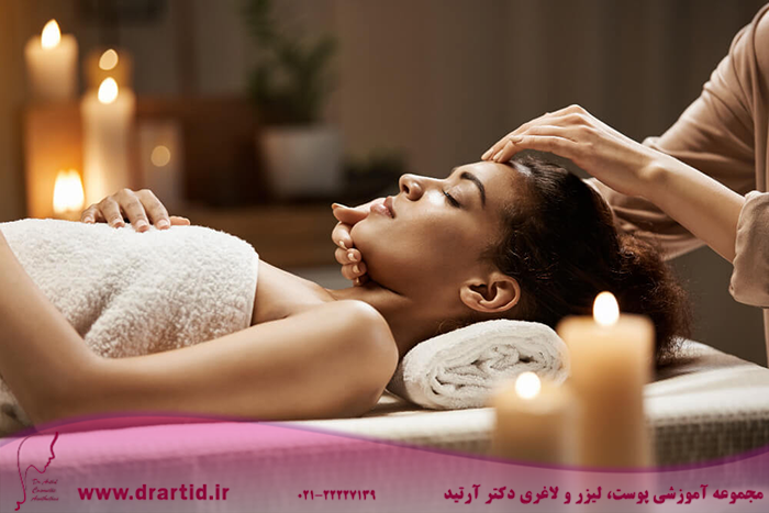 attractive african woman enjoying face massage spa salon - ماساژ صورت