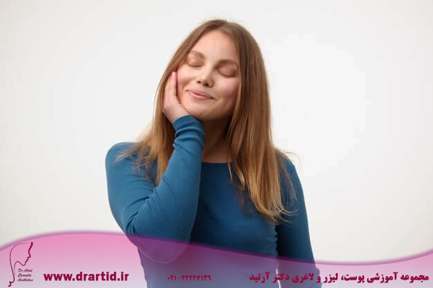 pleased young attractive blonde lady keeping her eyes closed while smiling gently touching her cheek with raised palm standing white background 295783 11917 - چگونه گونه‌ها و صورت پری داشته باشیم؟